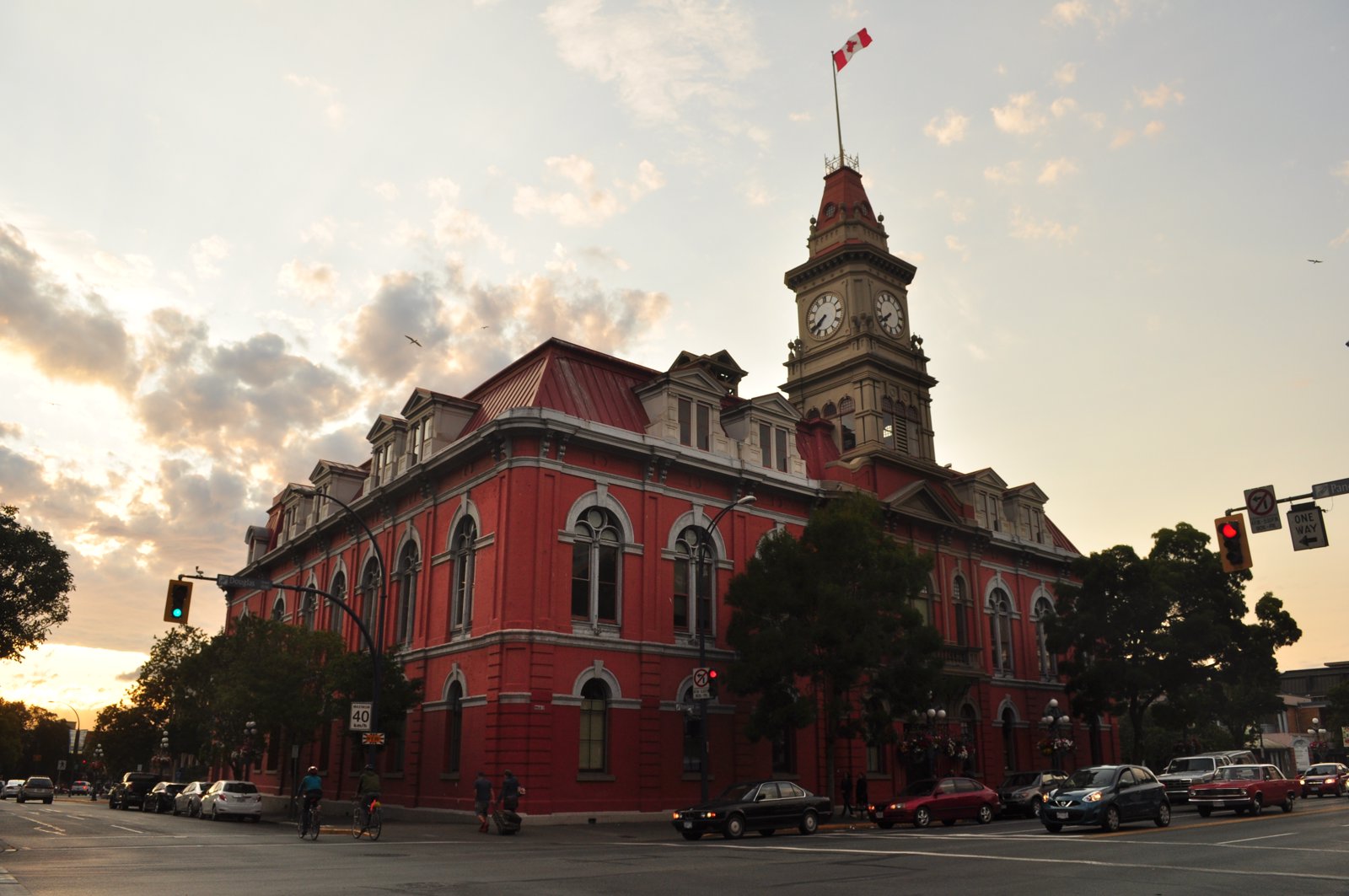 Victoria City Hall, a red-brick Victorian building with a central clock tower, seen from the street corner.